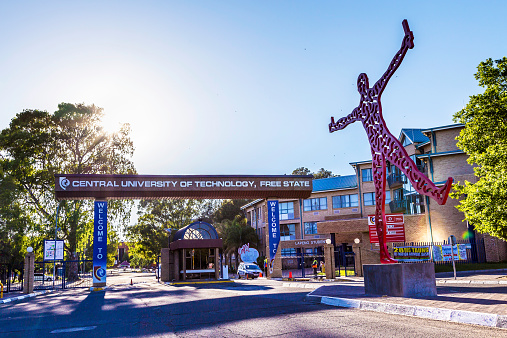 Bloemfontein, South Africa - November, 15th 2014: Central university of technology in Bloemfontein, Free state. A statue of joy seen in the front of the entrance to the university, holding a certificate. Security at ther entrance.